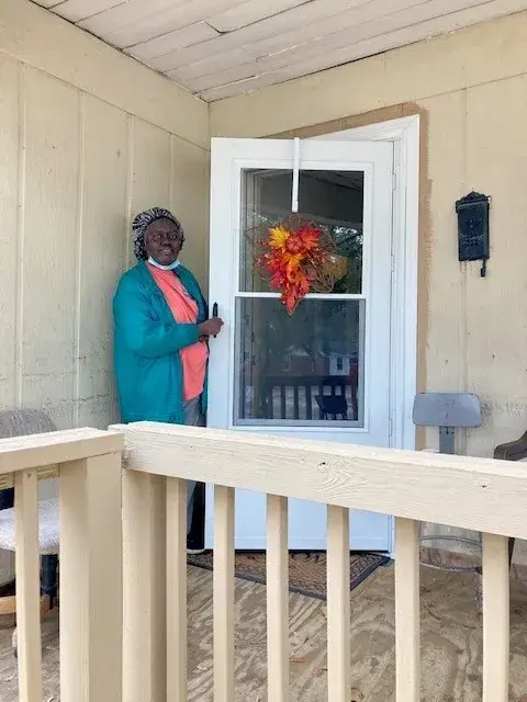 Resident standing outside on her porch