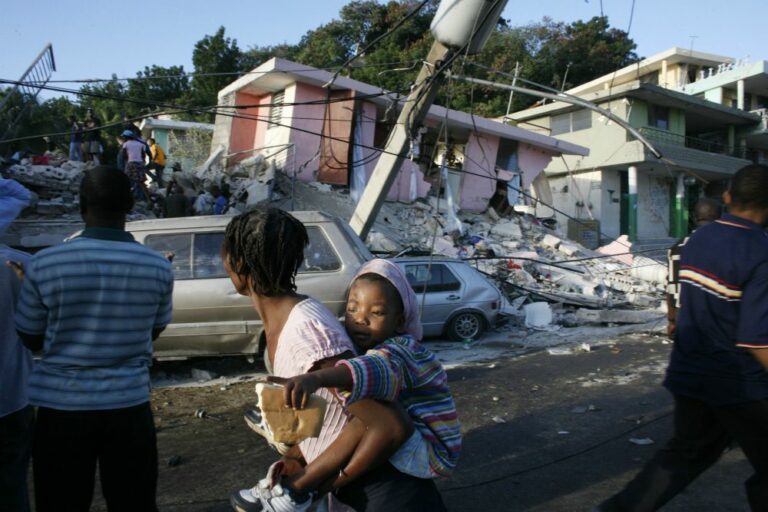 People walk past destroyed buildings in Port-au-Prince, Haiti, in 2010.