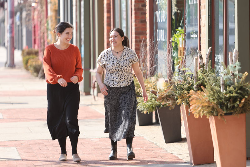 Two women walking down the street smiling