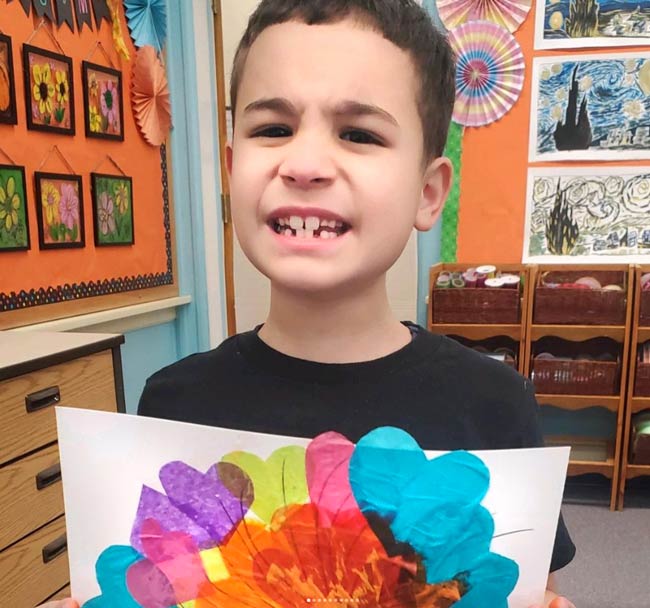 Boy holding his artwork.
