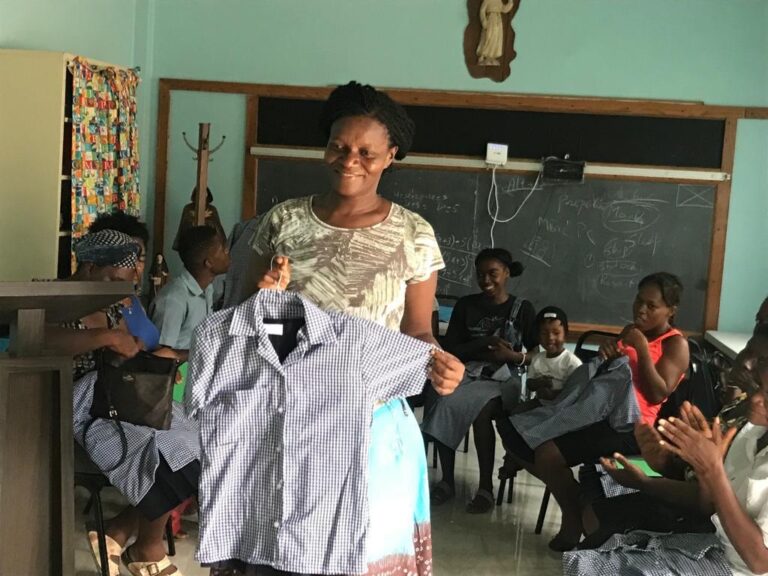 Sewing school student shows off uniform shirt.