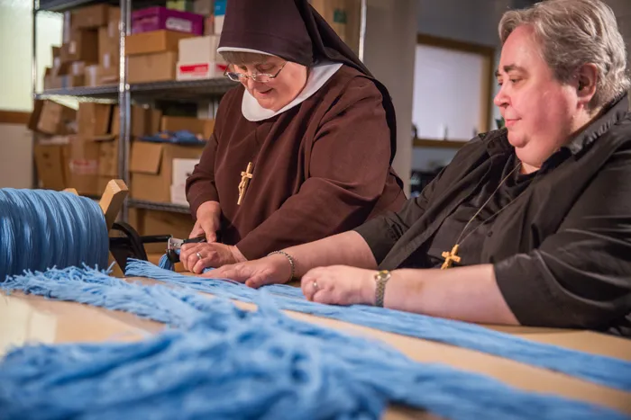 Two sisters making rosaries
